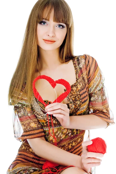 Mladá blondýna s červenou pletenou srdce — Stock fotografie