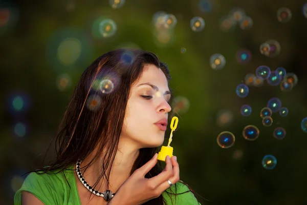 Молода дівчина дме мильні бульбашки — стокове фото
