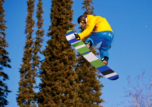 Snowboarder άλμα στον αέρα με βαθύ μπλε ουρανό στο παρασκήνιο — Φωτογραφία Αρχείου