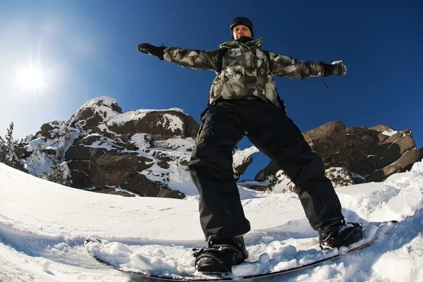 Snowboarder haciendo un tallado en el dedo del pie con cielo azul profundo en el fondo — Foto de Stock