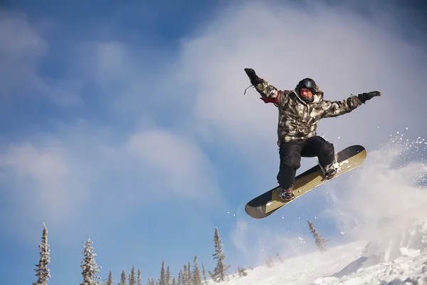 Snowboarder springen door de lucht met diep blauwe lucht op de achtergrond — Stockfoto