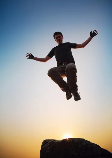 Boy jumping over the mountains — Stock Photo, Image