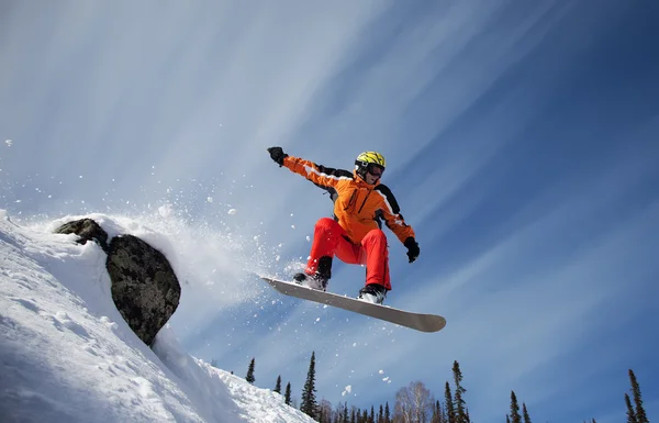 Snowboarder springt durch die Luft mit tiefblauem Himmel im Hintergrund — Stockfoto