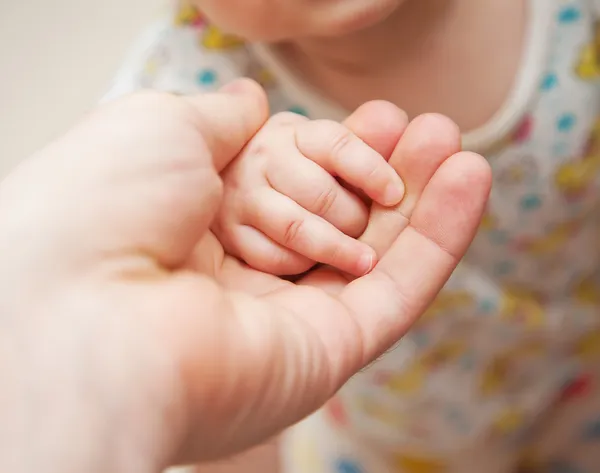Volwassen hand houden kid's handvol — Stockfoto