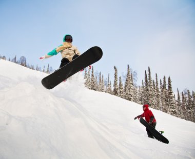 Snowboarder jumping through air with deep blue sky in background clipart