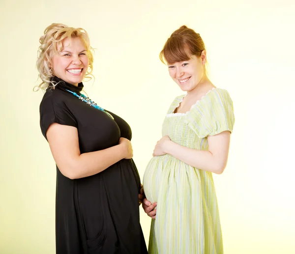 Zwei süße Schwangere tragen ihre großen Eingeweide isoliert — Stockfoto