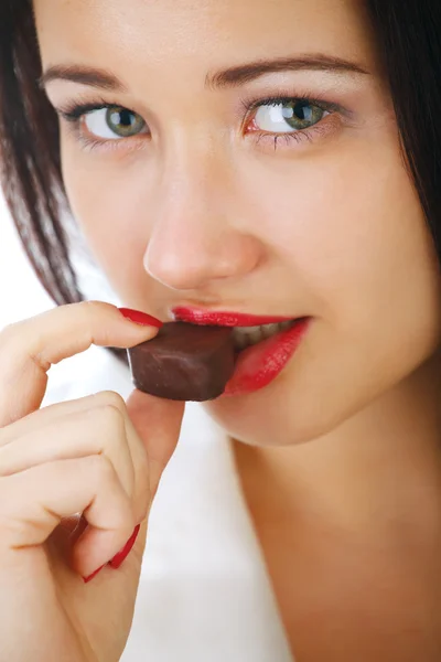 Mooi meisje met een chocolade snoep. — Stockfoto