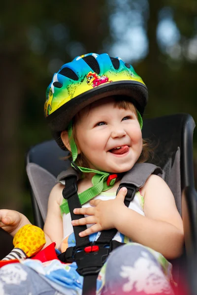 Κοριτσάκι σε κάθισμα ποδηλάτου με ένα κράνος στο κεφάλι του — Φωτογραφία Αρχείου