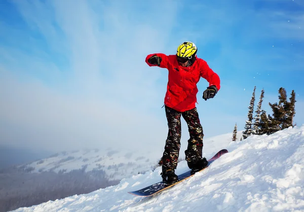 Snowboardåkare hoppa genom luften med blå himmel i bakgrunden — Stockfoto