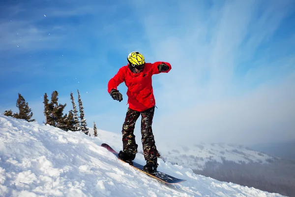 Snowboarder pulando pelo ar com céu azul no fundo — Fotografia de Stock