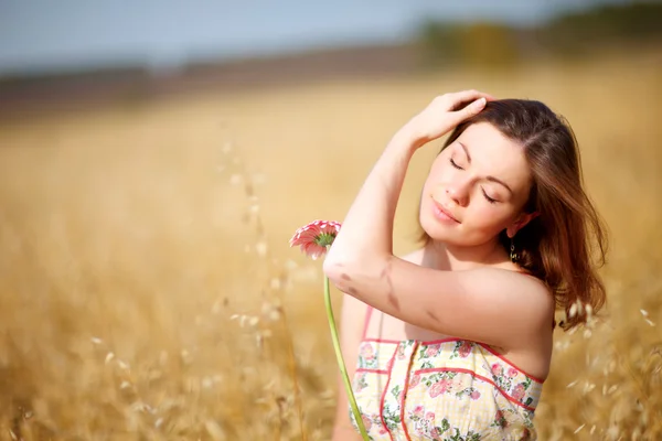 Mujer adorable en el campo con flor —  Fotos de Stock