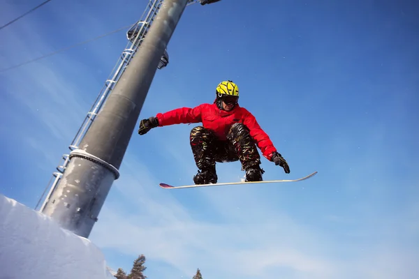 Snowboarder springt mit blauem Himmel durch die Luft — Stockfoto