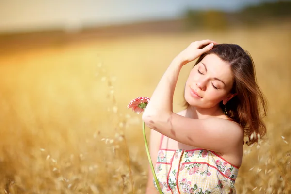 Schattig vrouw in veld met bloem — Stockfoto