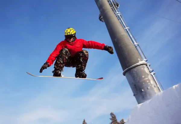 Snowboardista skoky vzduchem s modrou oblohou v pozadí — Stock fotografie