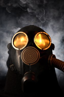 Man in gas mask over smoky background