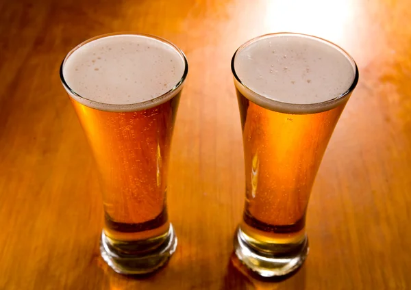 Two beer glasses on wood background — Stock Photo, Image