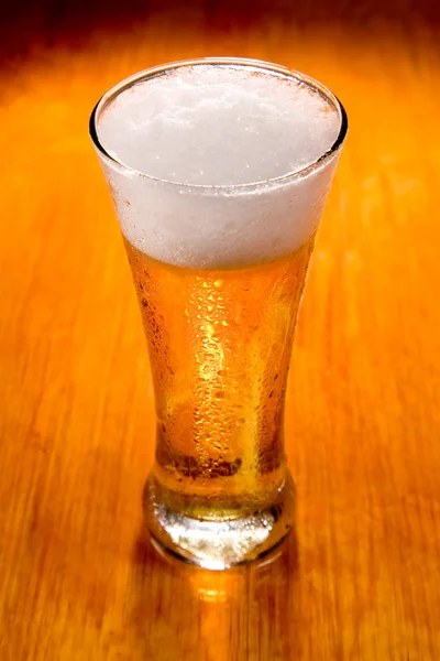 Copo de cerveja sobre fundo de madeira — Fotografia de Stock