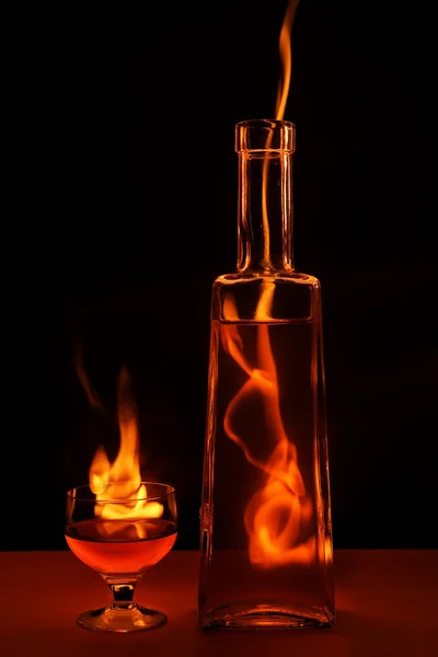 Бутылка и стекло в огне Стоковое Фото