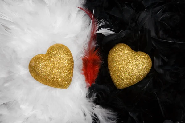 Two hearts over white and black feathers background — Stock Photo, Image