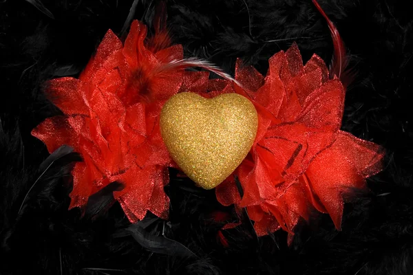 Golden heart over black feathers background — Stock Photo, Image