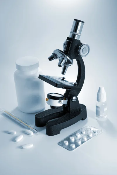 Mikroskop och piller Stockfoto