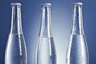 Soda bottles with caps and water drops clipart