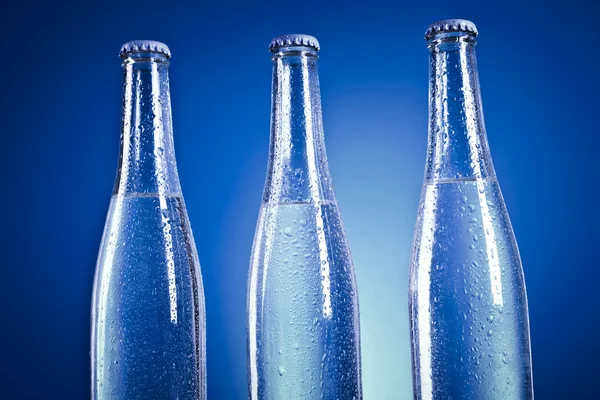 Transparent soda flaskor med lock och vattendroppar — Stockfoto
