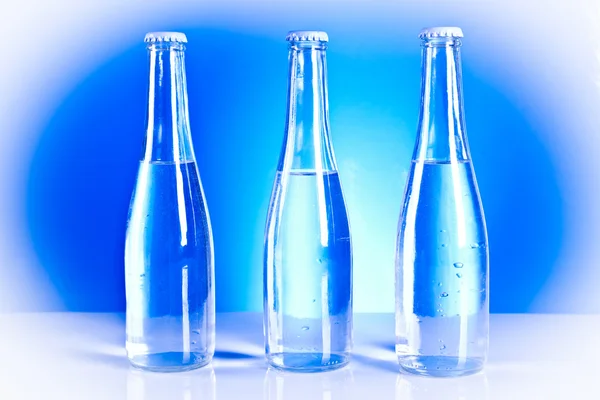 Бутылки с газировкой и капли воды — стоковое фото
