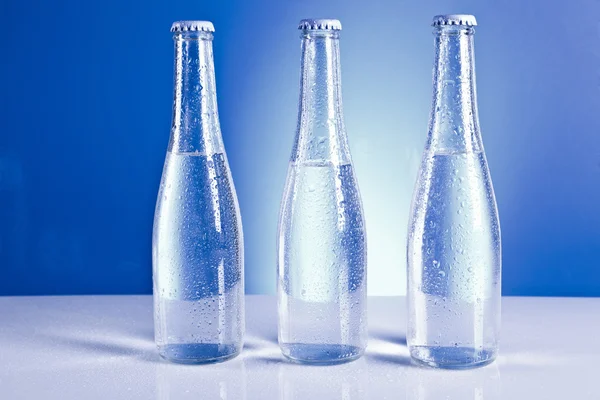 Soda flaskor med lock och vattendroppar — Stockfoto