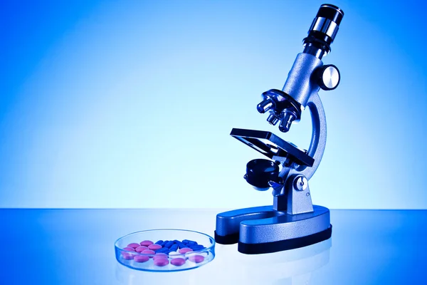 Microscope and laboratory glassware — Stock Photo, Image