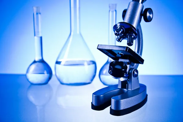 Microscope and laboratory glassware — Stock Photo, Image