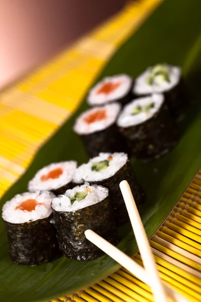 Deliciosos rollos de sushi con palillos —  Fotos de Stock