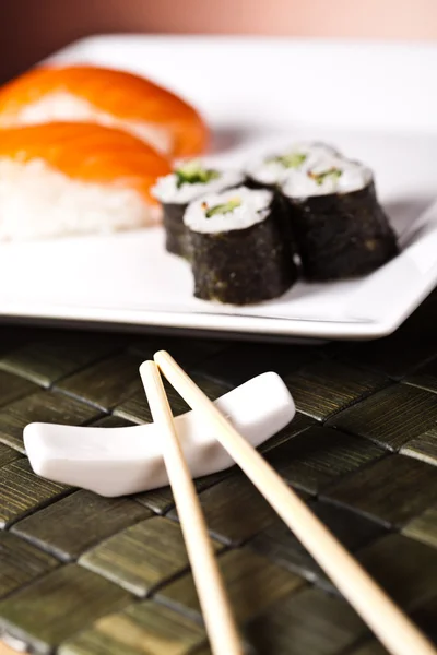 Суши на тарелке с палочкой для еды — стоковое фото