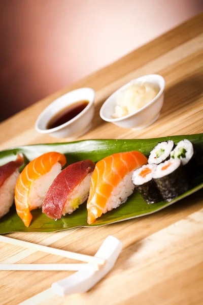 Sushi y rollos en la hoja —  Fotos de Stock