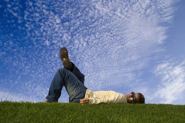A fiatalember a fűben fekve — Stock Fotó