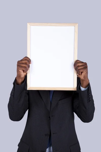 Empresário africano segurando um quadro branco — Fotografia de Stock