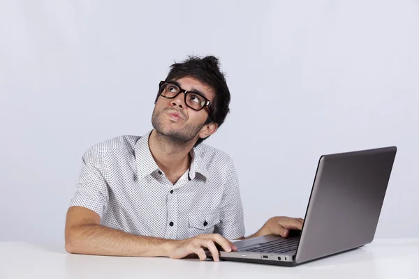 Молодой человек работает со своим ноутбуком Стоковое Изображение