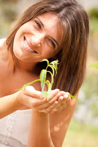 Kobieta trzymająca roślinę — Zdjęcie stockowe