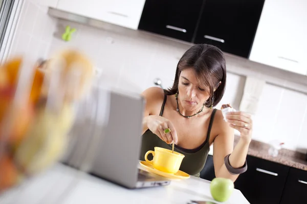 现代女人她早餐时阅读的电子邮件 — 图库照片