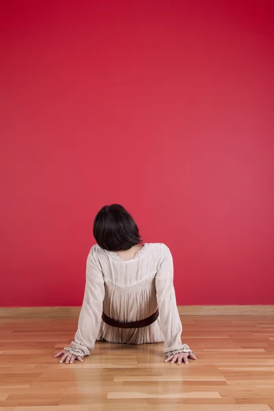 Женщина смотрит на красную стену — стоковое фото