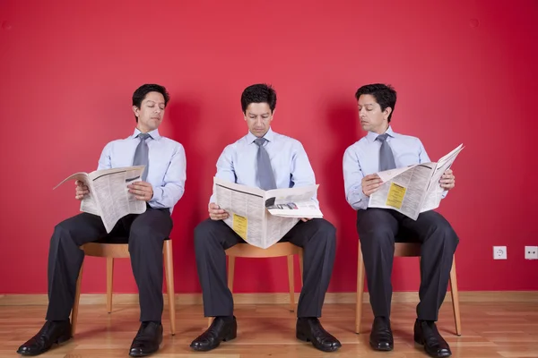 Трое бизнесменов читают газету — стоковое фото