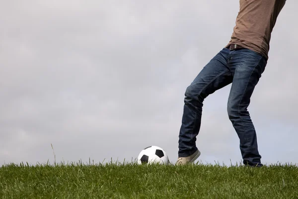 Человеческая нога и футбольный мяч — стоковое фото