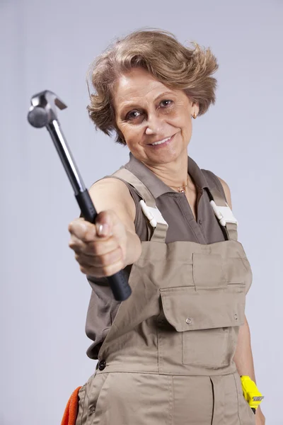 Äldre kvinna med en hammare — Stockfoto