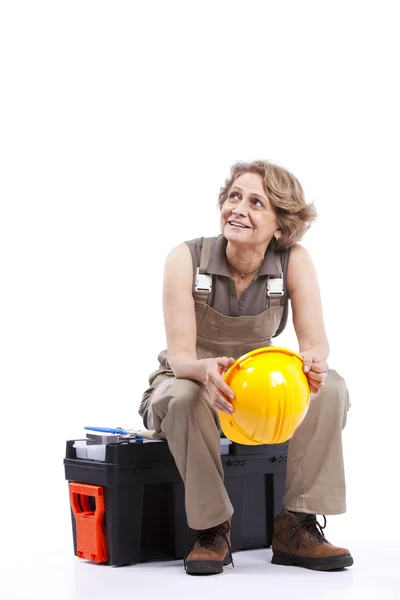 Mujer mayor sentada en una caja de herramientas — Foto de Stock
