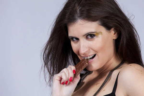 Woman biting chocolate — Stock Photo, Image