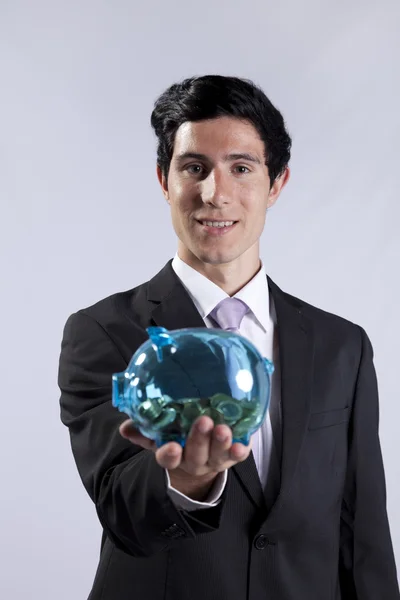 Businessman holding a piggybank full of coins — Stock Photo, Image