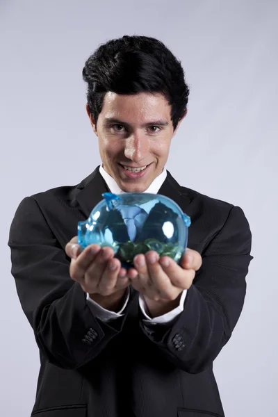Businessman holding a piggybank full of coins — Stock Photo, Image