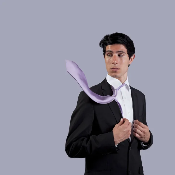 Businessman looking to his flying necktie — Stock Photo, Image