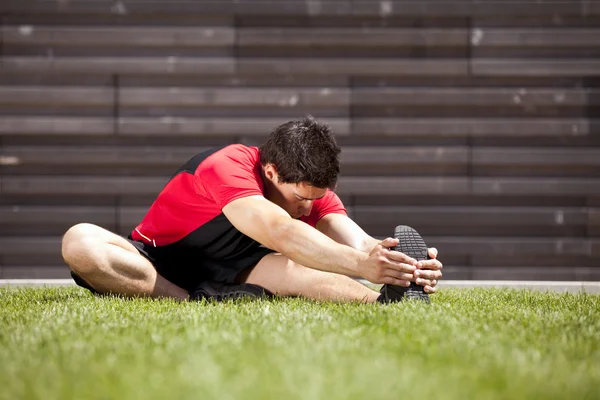 Athlete warming and stretching — Stock Photo, Image