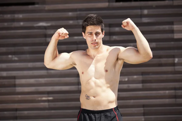 Спортсмен показывает свои мускулы — стоковое фото